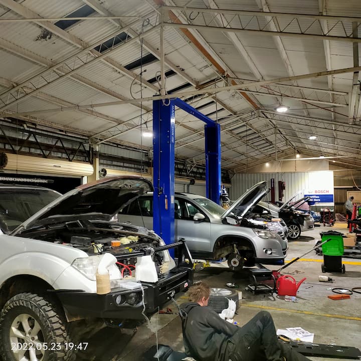 Three vehicles being worked on at once on the workshop floor